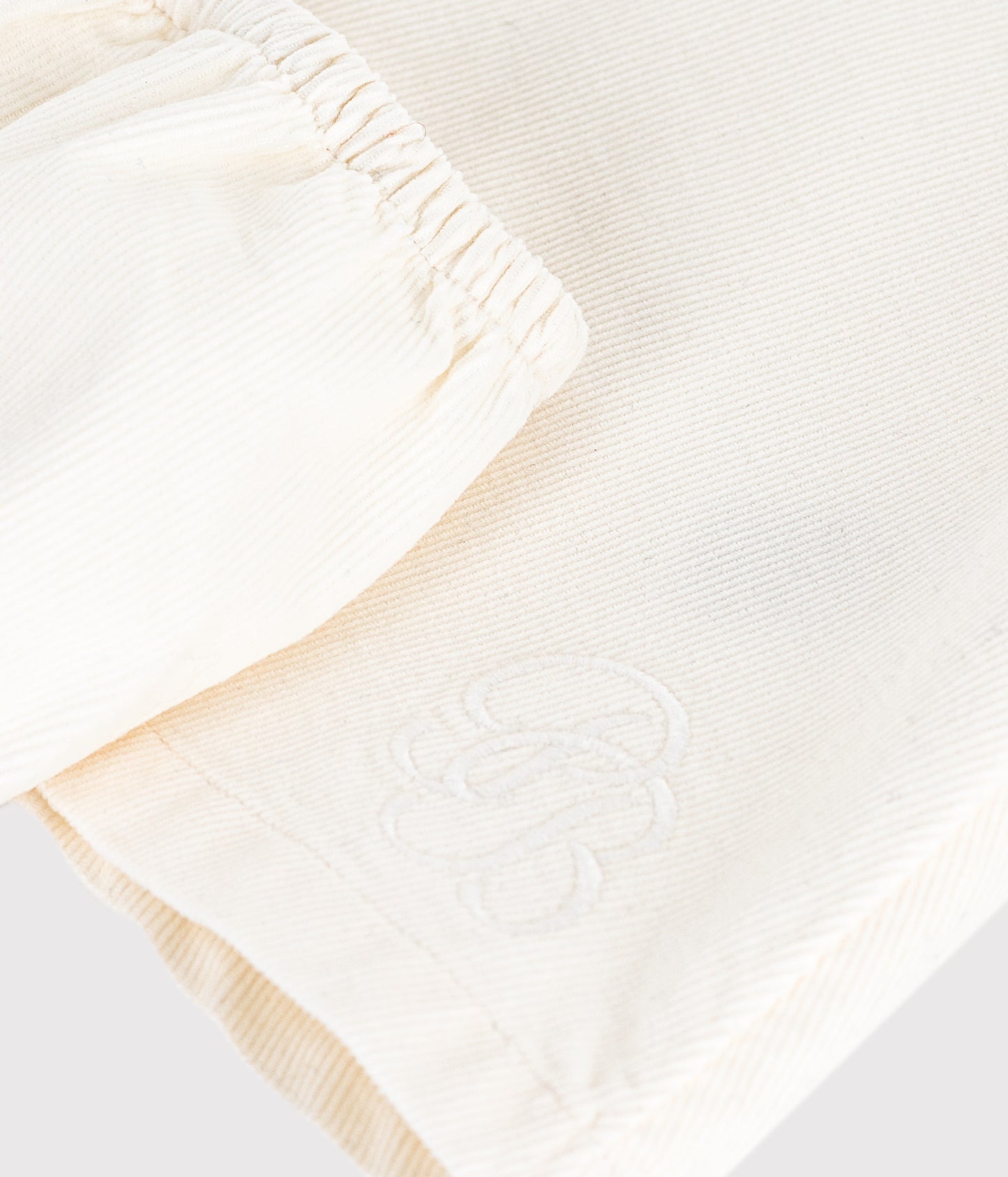 Råhvid fløjlskjole med broderet logo til baby